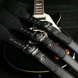 3" wide black pebble finished leather guitar strap top view with assorted clipped corner buckle colors on a Gibson Les Paul guitar