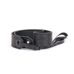 black leather camera strap with black grommets showing the Slinger Straps logo