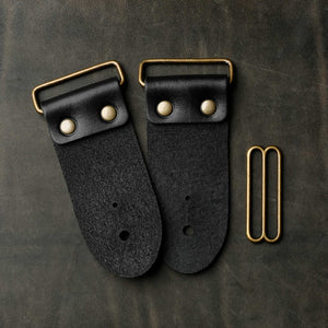 backside of black leather guitar strap end kit for a guitar strap with antique brass hardware