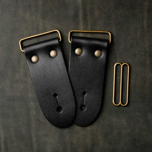 frontside of black leather guitar strap end kit for a guitar strap with antique brass hardware