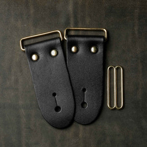 frontside of black leather guitar strap end kit for a guitar strap with gold hardware