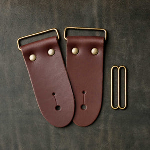 frontside of brown leather strap end kit for a guitar strap with antique brass hardware