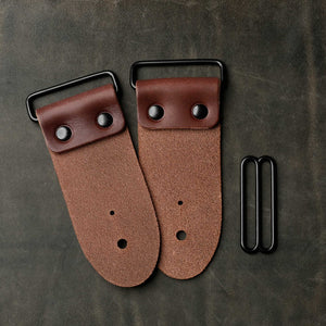 backside of brown leather strap end kit for a guitar strap with black hardware