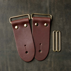 frontside of brown leather strap end kit for a guitar strap with gold hardware