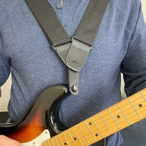 leather shoulder strap adapter that connects two shoulder straps to one attachment piece on a fender stratocaster