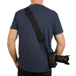  man with a camera strap made of 2" wide heavy-duty elastic material over left shoulder