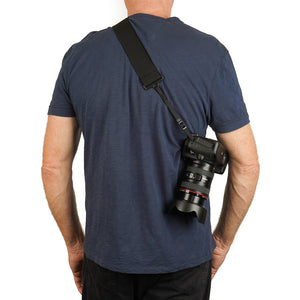 Rear view of a camera strap made of 2" wide heavy-duty elastic material attached to a Canon camera