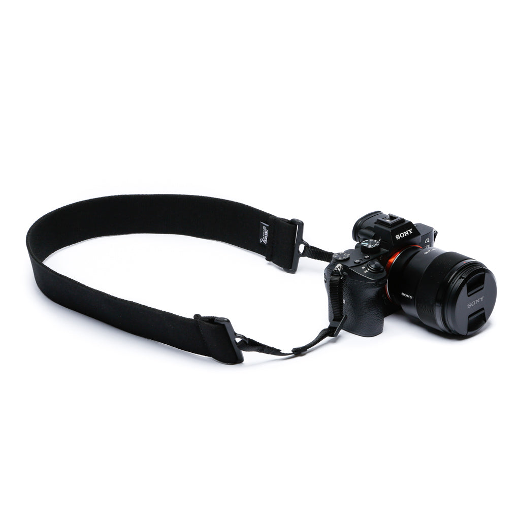 Camera strap made of 2" wide heavy-duty elastic material attached to a Canon camera