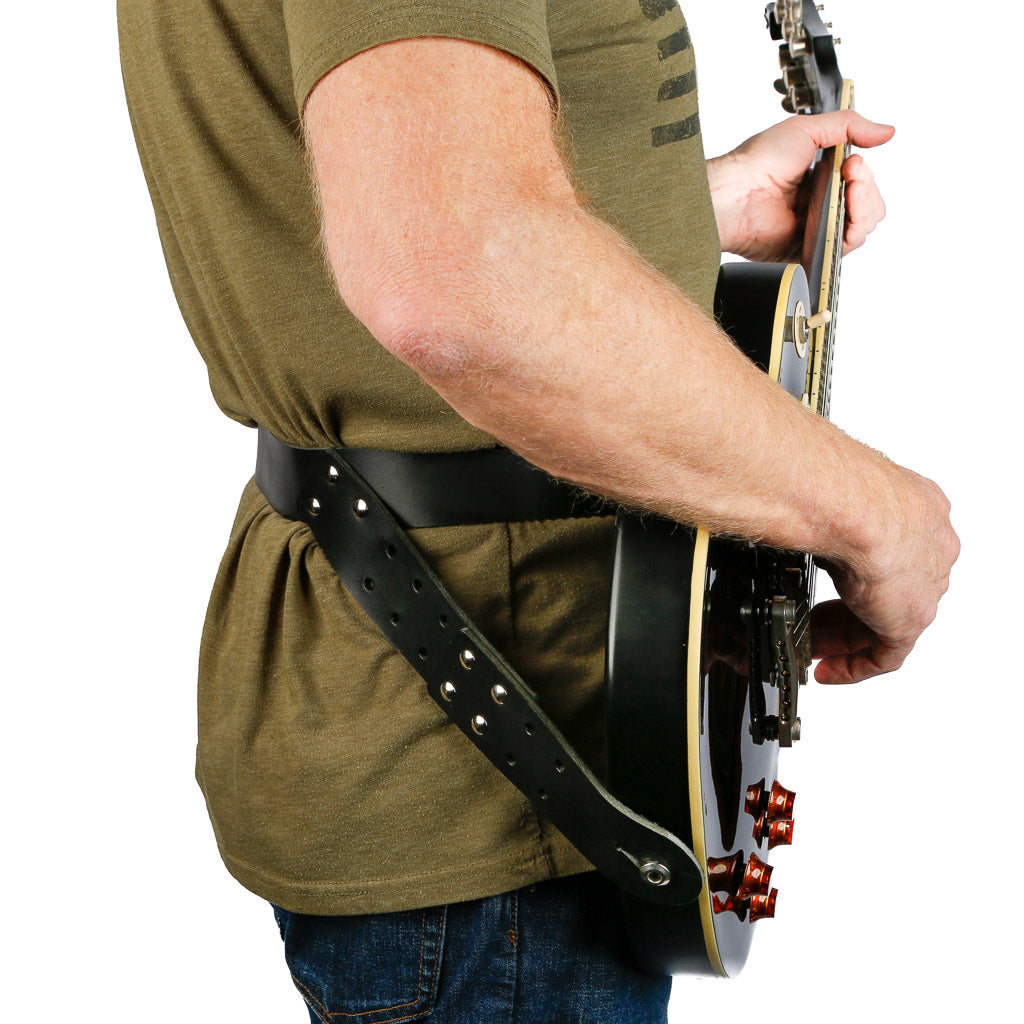 https://slingerstraps.com/cdn/shop/products/straps_leather_hip_strap_waist_guitar_strap_on_man_playing_a_gibson_les_paul_right_side_view_1200x.jpg?v=1681952572
